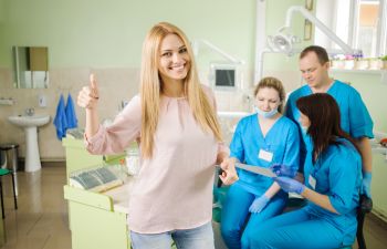 Happy patient with a dentist with thumbs up