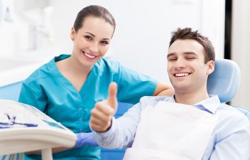 Happy patient with a dentist with thumbs up