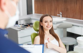 Happy patient with a dentist with thumbs up