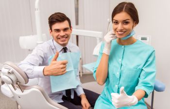 Happy patient with a dentist with thumbs up