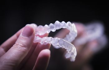 woman holding invisalign