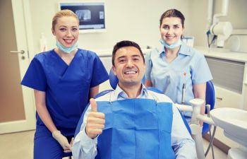 Happy patient with a dentist with thumbs up