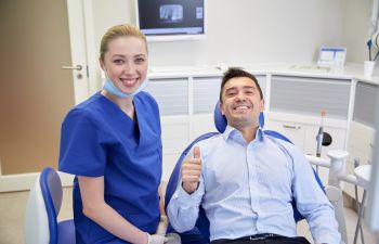 Happy patient with a dentist with thumbs up