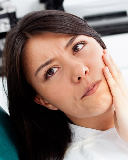 a dark haird woman with toothache