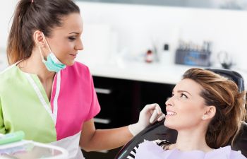 Dental Patient in Chair Discussing Treatment with Hygienist