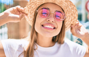 smiling girl in pink glasses and hat, 